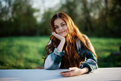 Portrait of young woman sitting on table