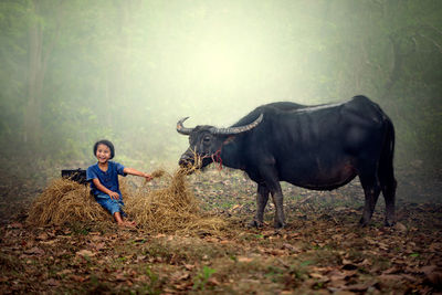 Portrait of boy with horse in forest