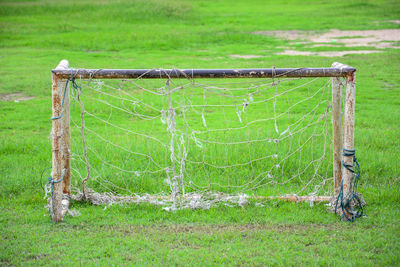 Close-up of abandoned goal post on grassy field
