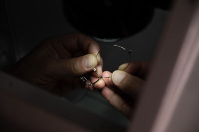 Cropped hand of person holding broken eyeglasses