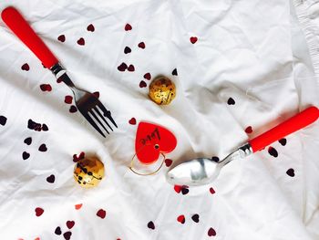 Close-up high angle view of decoration and eating utensil on white fabric