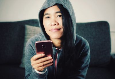Portrait of woman using mobile phone at home