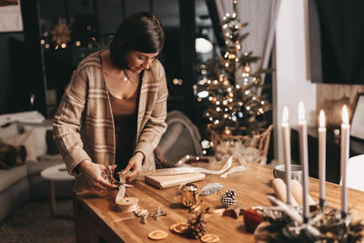 Good mood woman in a cozy environment wrapping gifts for christmas, stylish decoration, vintage