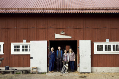 Farmer standing with family at doorway of barn
