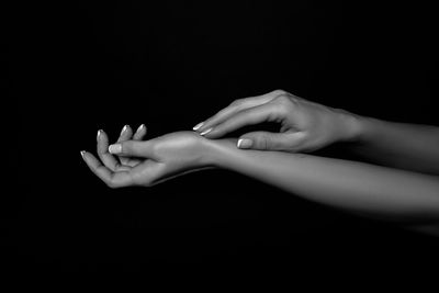 Close-up of woman hand against black background