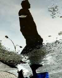 Low section of man on beach against sky