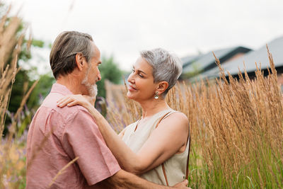 Side view of couple kissing on field