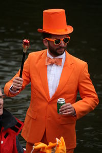 Man wearing hat standing by lake