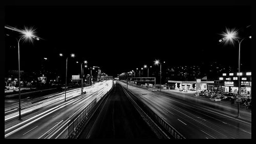 Railroad tracks against sky at night