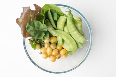 High angle view of vegetables in bowl against white background