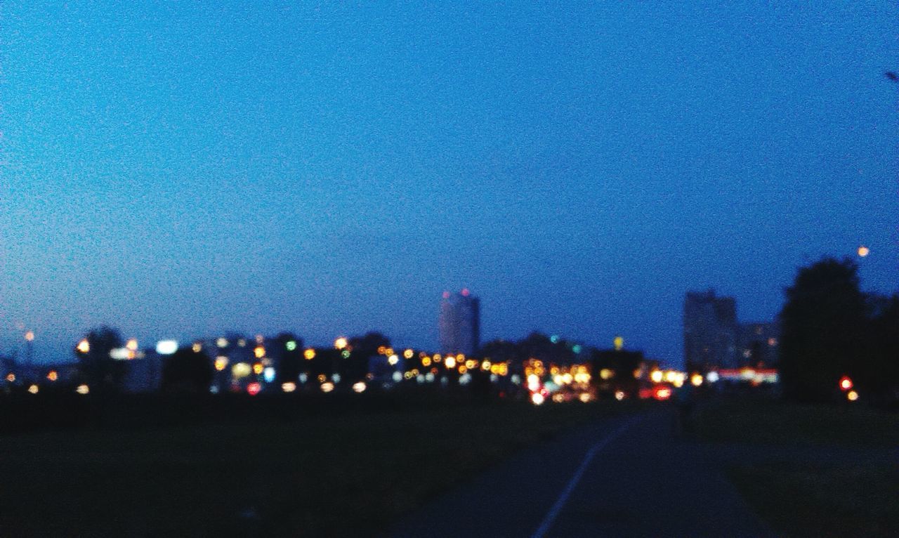 illuminated, night, lighting equipment, sky, dusk, building exterior, blue, defocused, road, street, architecture, street light, built structure, light - natural phenomenon, copy space, city, clear sky, outdoors, no people, dark