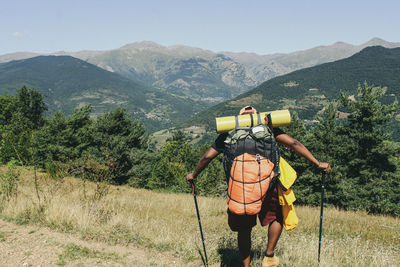 Rear view of woman on mountain against sky