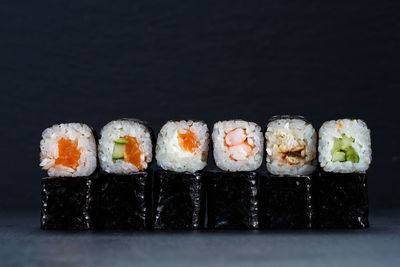 Close-up of sushi served on table against black background