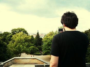 Woman photographing through tree