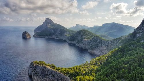 Scenic view of sea and mountains against sky