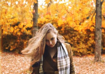 Portrait of beautiful young woman with autumn leaves