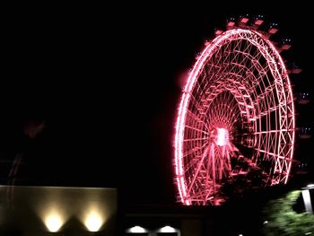 Low angle view of ferris wheel at night