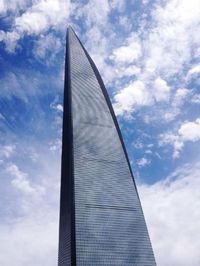 Low angle view of modern building against cloudy sky
