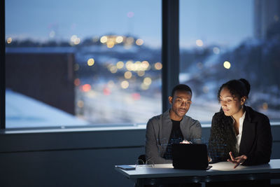 Two young business people working together in office