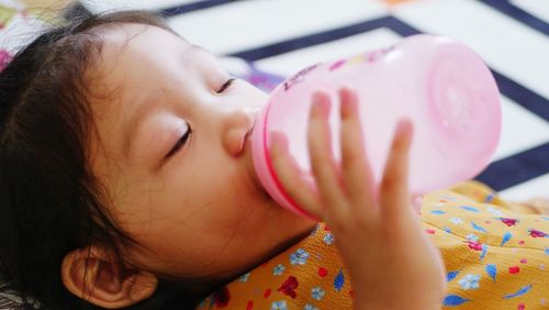 Close-up of cute girl drinking water