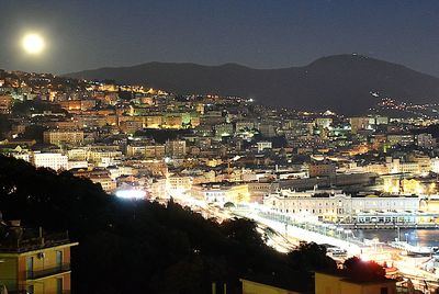 Illuminated cityscape against sky at night