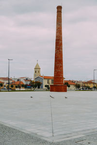 Tower of building against cloudy sky