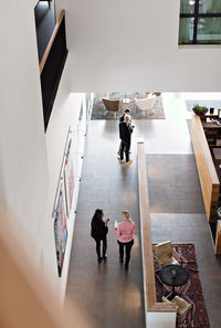 High angle view of businesswomen discussing while walking in corridor