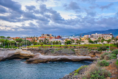 View of townscape by sea against sky