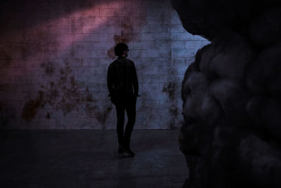 Rear view of silhouette man standing in corridor