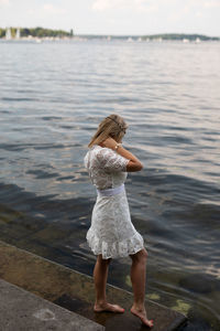 Rear view of woman standing in lake