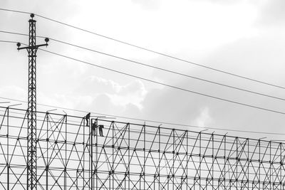 Silhouette people on scaffolding against sky