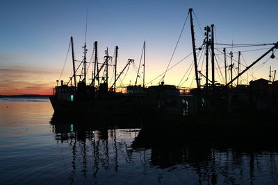 Silhouette of boats in sea during sunset