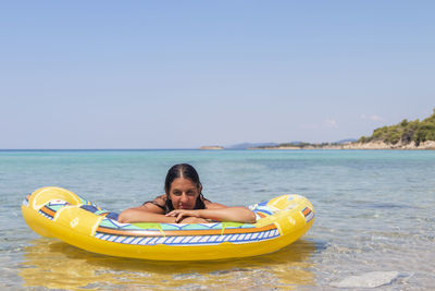 Idyllic summer vacation.a beautiful teen girl in a bikini relaxes in a sea lagoon on an air mattress