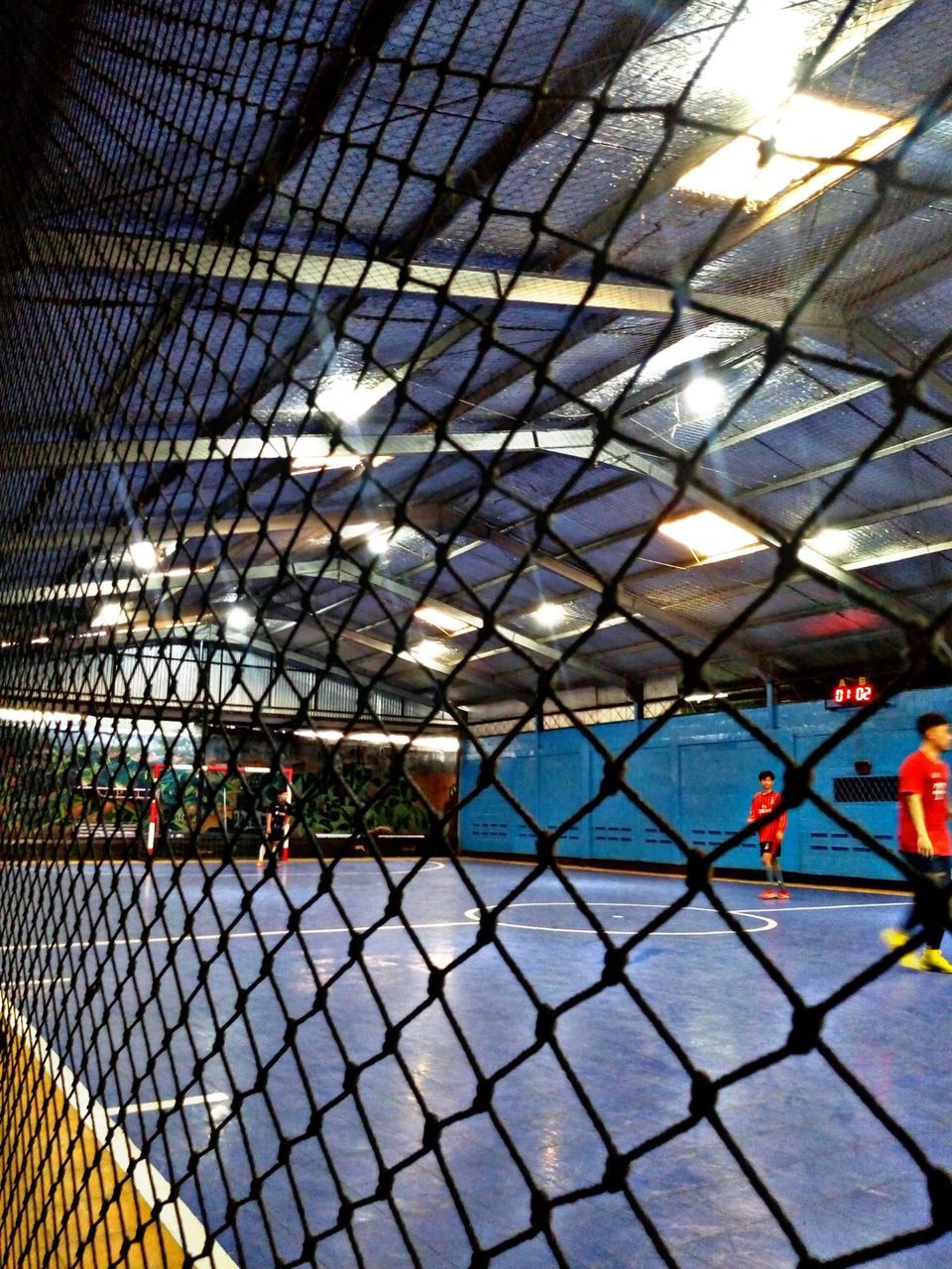 METAL FENCE BY SWIMMING POOL SEEN THROUGH CHAINLINK WINDOW