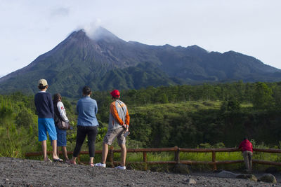 Rear view of people walking on mountain road