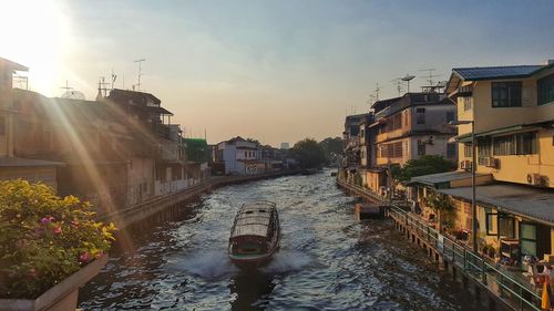 Canal amidst buildings in city against sky