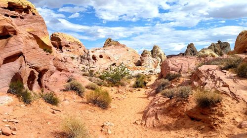 Rock formations on landscape against cloudy sky