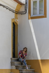 Woman sitting outside building