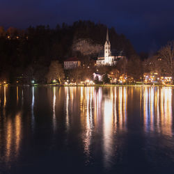 Night on lake bled. christmas atmosphere and lights. castle and church of the annunciation