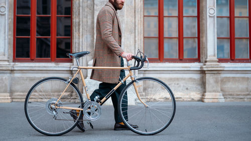 Midsection of walking hipster with bicycle. eco friendly transport in city