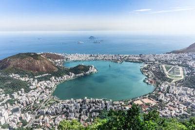 High angle view of city by sea against sky