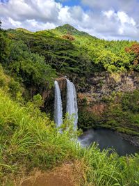 Scenic view of waterfall against sky