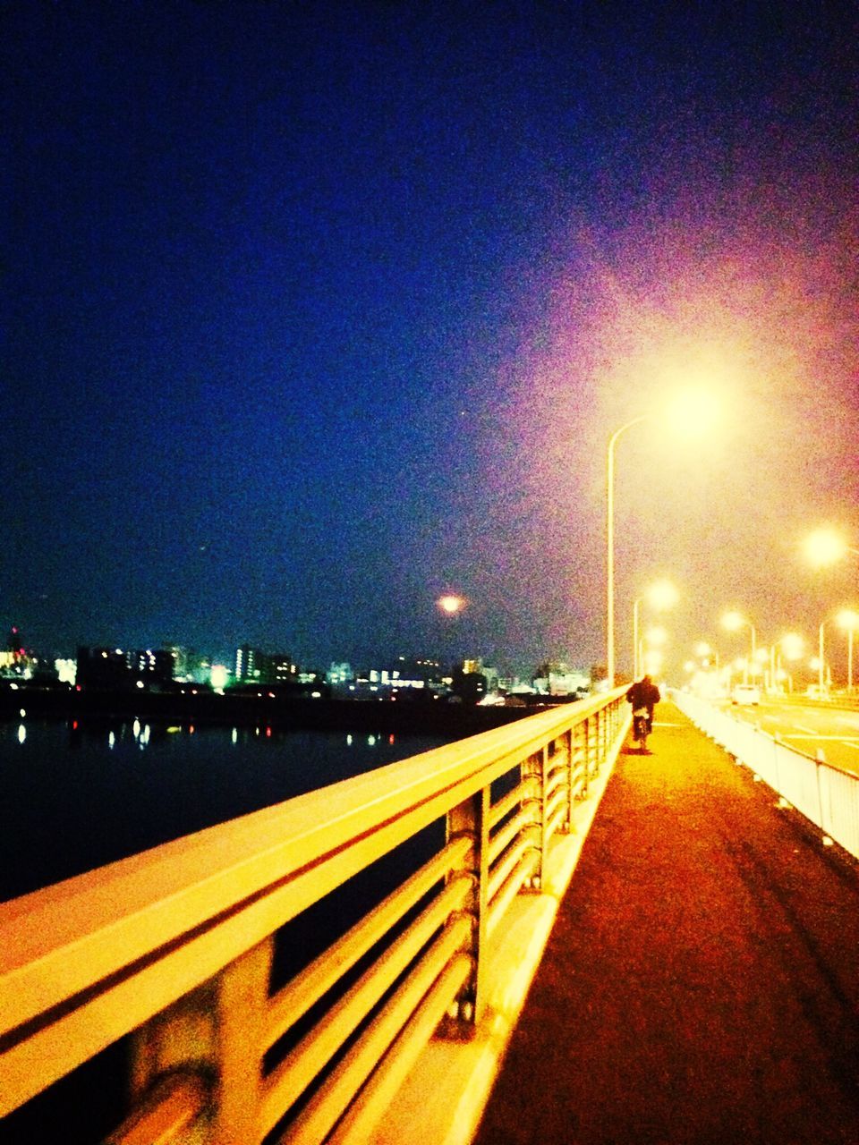 illuminated, night, street light, the way forward, transportation, lighting equipment, road, clear sky, copy space, railing, city, diminishing perspective, built structure, sky, light trail, street, architecture, empty, light - natural phenomenon, connection