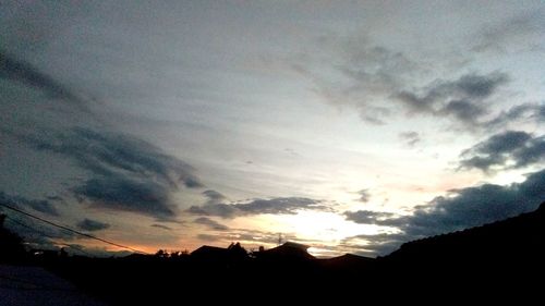 Low angle view of silhouette landscape against dramatic sky