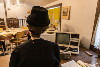 Rear view of man standing at home