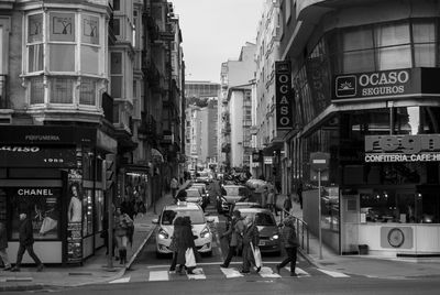 People and cars on street in city