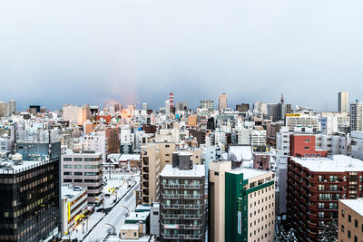 High angle view of urban skyline against cloudy sky