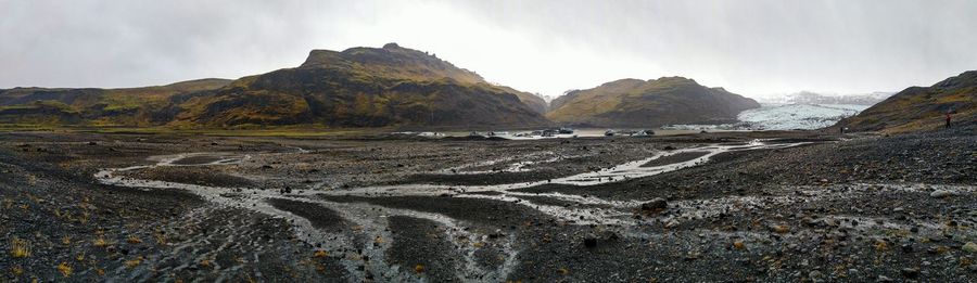 Scenic view of land and mountains against sky