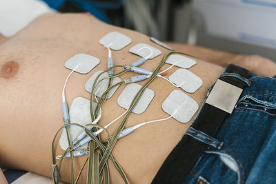 Shirtless man receiving electro stimulation treatment