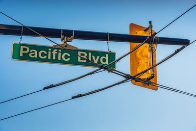 Low angle view of road sign against blue sky